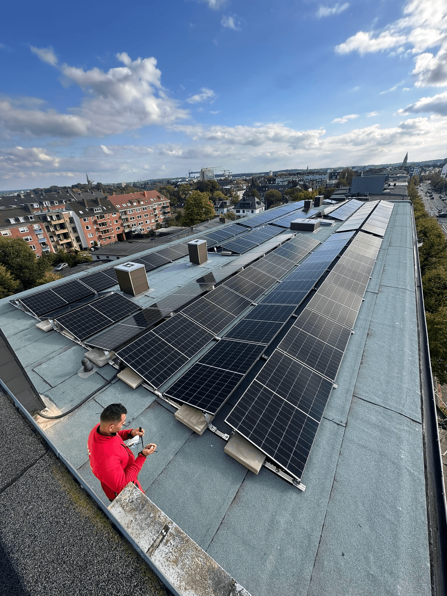 BSH-Monteur bei der Installation einer Gewerbe-Photovoltaik-Anlage auf einem Flachdach in Kiel