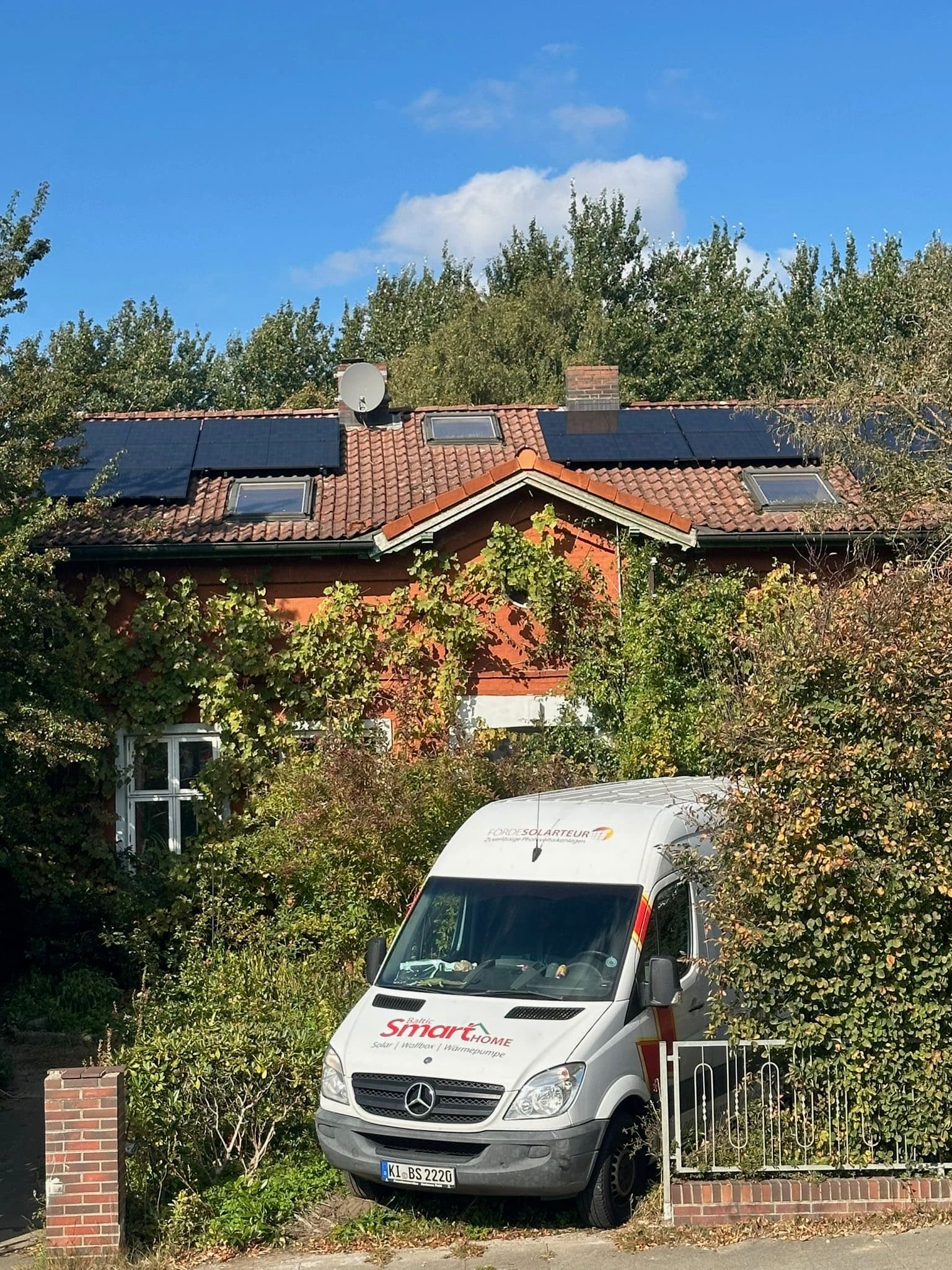 Einfamilienhaus mit fertiger Photovoltaikanlage und BSH-Servicefahrzeug davor