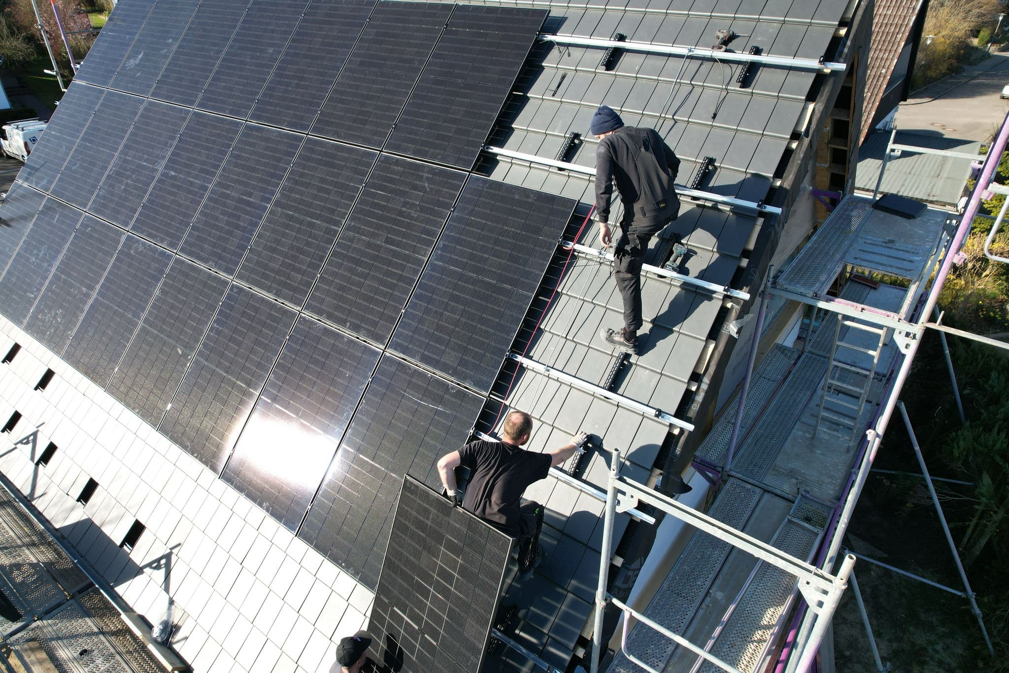 Zwei BSH-Monteure auf dem Dach beim Setzen der Solarmodule
